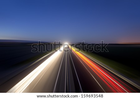 Car light trails at night on highway.