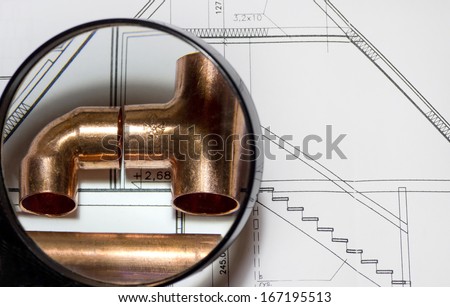 Plumbing equipment on house plans under the magnifier.