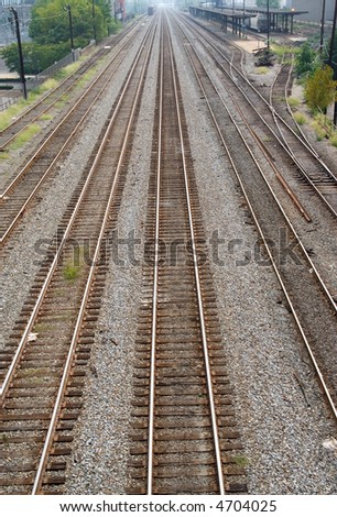 A vertical composition of six sets of train tracks disappearing into the horizon.