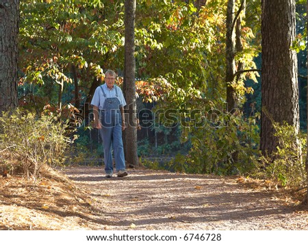 An old man walking in the woods.