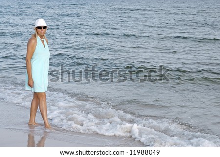 A woman walking alone by the sea.