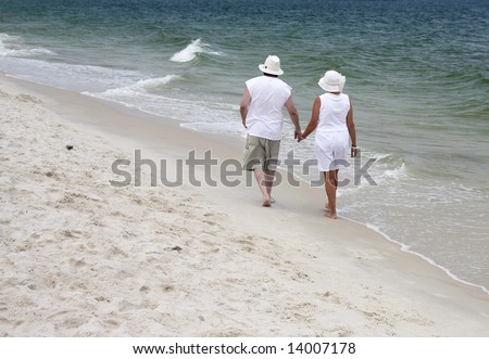 A couple walking together on the beach in Gulf Shores Alabama.