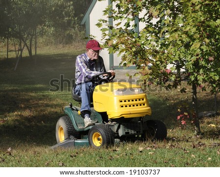 A man mowing his lawn with a lawn tractor.