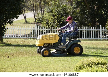 A man mowing his lawn with a riding mower.