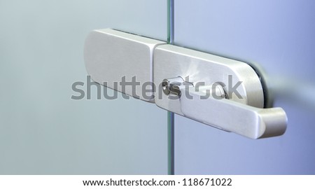 Modern metal office door handle on a glass door