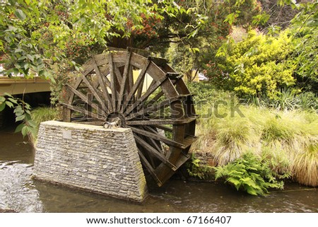 image of a water wheel beside river at avon river, christchurch new zealand