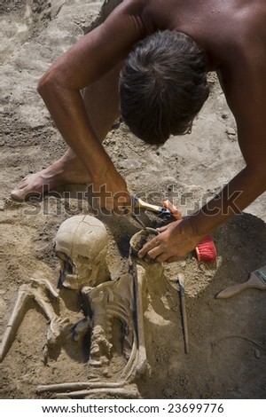 Archaeologist excavating prehistoric grave human skeleton