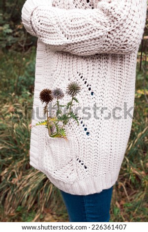 Woman in wool sweater having thistle in her pocket
