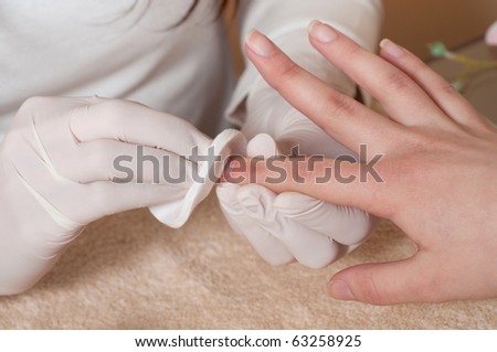 Removing lacquer from manicured nails with white cotton pad