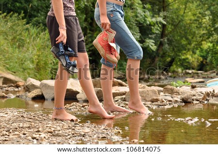 Two teenage girls cooling off their feet in a creek in the Belgian Ardennes
