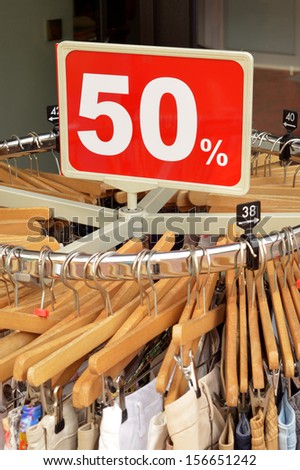 Sale in a clothing store - 50% discount sign at a clothes rack