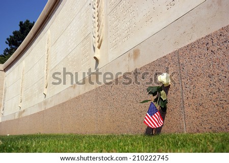 COLLEVILLE SUR MER, FRANCE - JULY 24:  A rose and American flag in front of Walls of the Missing at The Normandy American Cemetery on July 24, 2014 in Colleville-sur-Mer, France