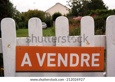 A Vendre - House for sale sign at a fence of a french home in Brittany, France