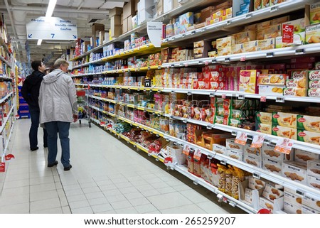 WALLONIA, BELGIUM - OCTOBER 17: Consumers shopping in the Cookies section. Aisle with a variety of packaged biscuits products in a Carrefour Hypermarket on October 17, 2014 in Wavre, Belgium