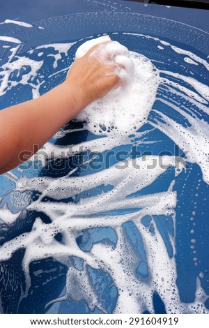 The hand of a child washing a car