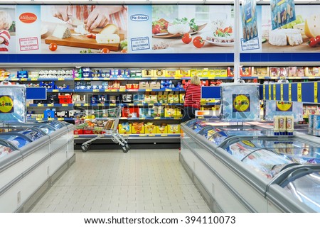 MALMEDY, BELGIUM - JULY 29, 2015: Interior of a Lidl supermarket. Shopper in the refrigerated fresh products aisle. Lidl is a German discount chain, 9800 stores, in 28 countries in Europe.