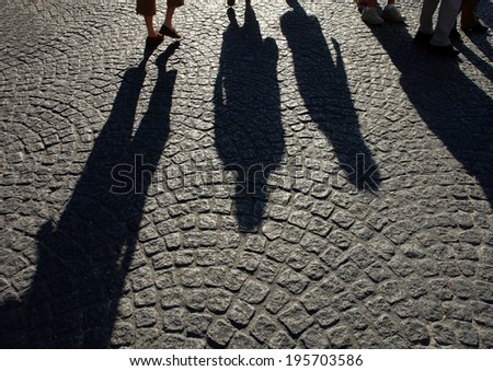 shadows of people on the pavement of stones. the shadow of the man on the rocks
