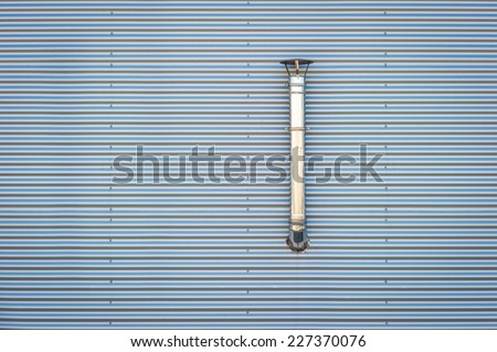 Ventilation pipe on a metallic wall at industrial premises