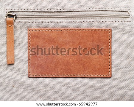 blank leather label stitched onto the canvas with zipper