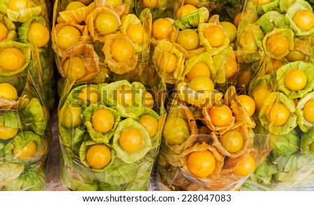 Group of fresh cape gooseberry in plastic bags on stall in a Asia market