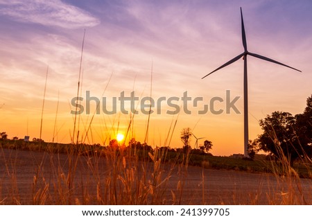 Wind turbines power generator on sunset at farmer field