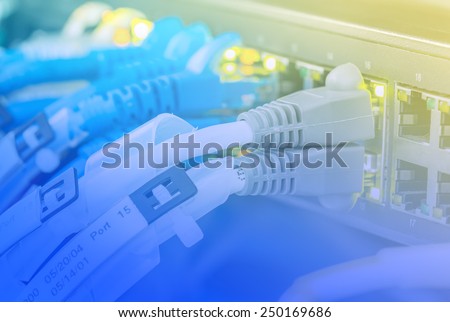Ethernet copper cables with grey connector plug in to equipment in data center