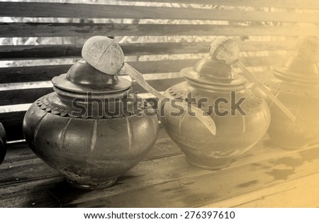 Thai style clay jar for drinking water and coconut dipper in monochrome tone
