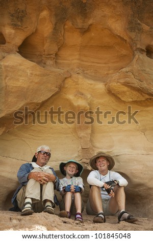 Family of three take a rest from trekking in Utah desert