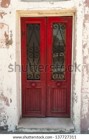 Old bright red doors set in a white wall, Burano, Italy