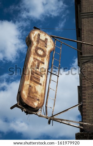 Old, decrepit, weathered sign for a hotel