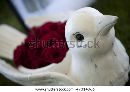 Bird-shaped flower vase with roses in it.