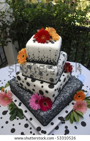Ornate multi-tiered wedding cake with black polka-dots