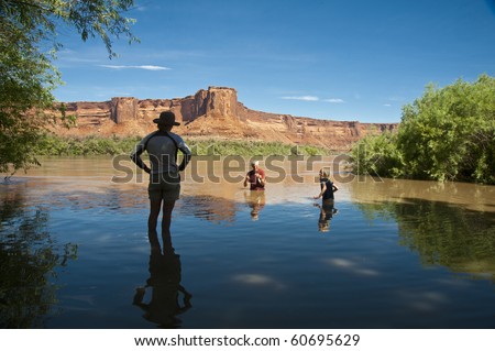 Family swimming in desert river in the canyon country of Utah