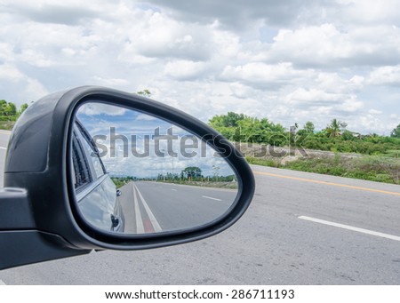 road and blue sky,rear view in car mirror