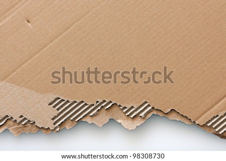 Old textured cardboard sheet with torn edges isolated over white