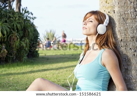 beautiful girl listening music on grass in really good day