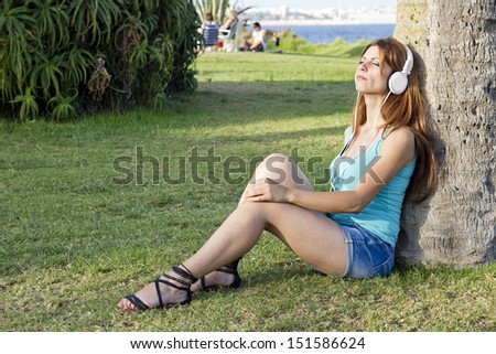 beautiful girl listening music on grass in really good day