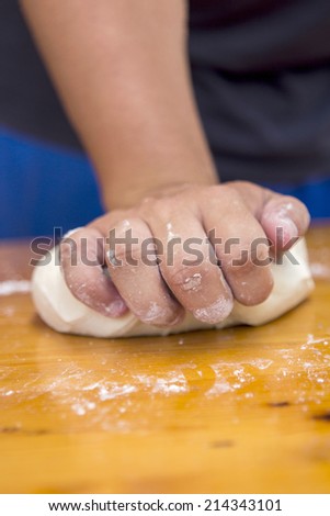 Chef preparing dough and ingredients of pizza at the kitchen