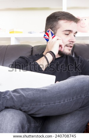 Guy using phone sitting on the sofa
