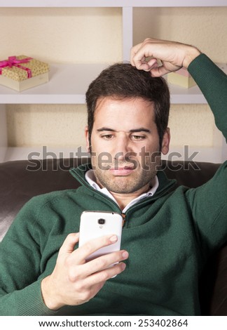 Handsome guy relaxed and using technology on sofa