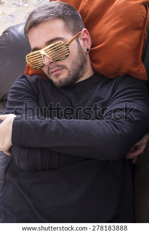 Asleep guy on the sofa wearing gold glasses