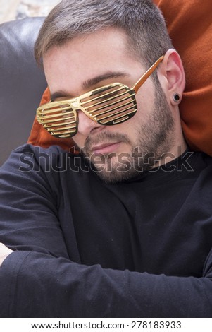 Asleep guy on the sofa wearing gold glasses