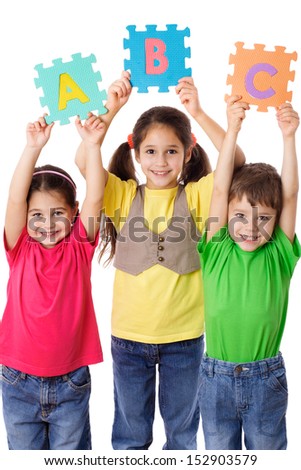 Three kids with colorful letters in raised hands, isolated on white