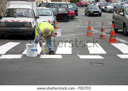 French blue collar worker painting the crossing lines