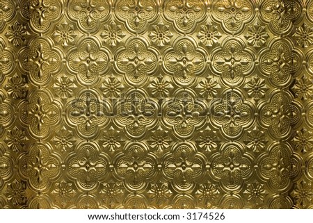 Closeup of a golden, decorative glass panel in warm sunlight, well focused showing the design in detail.