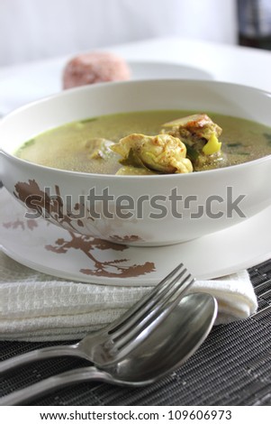 A Chicken Clear soup withe Fork and  Spoon