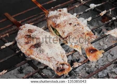 Grilled fish on grill with rest, selective focus
