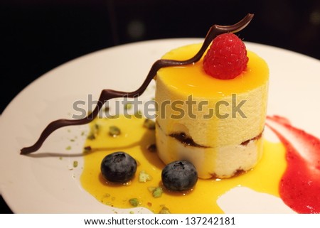 Delicious Mango Mousse Cake topped with strawberries and chocolate
