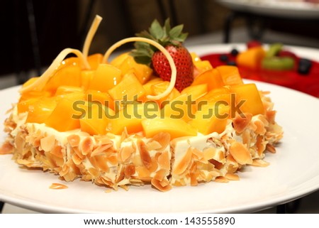 A Mango cake decorated with almonds trawberry