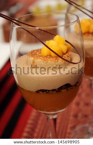 Glass of chocolate mousse  topped with whipped cream and fruit